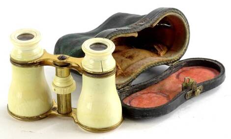 A pair of late 19thC/ early 20thC ivory and gilt metal opera glasses, unmarked, in a leather case, (AF).