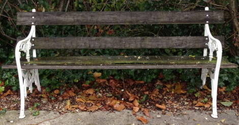 A slatted cast iron garden bench, with Gothic style end supports, decorated with leaves, etc., 190cm wide.