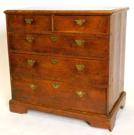 A late 18th/ early 19thC oak chest of drawers, the top with a moulded edge above two short and three long drawers, each with engraved brass handles on bracket feet, 89cm high, 91cm wide, 52cm deep.