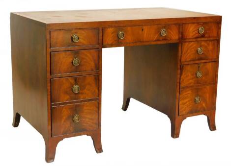 A mahogany kneehole desk, the rectangular top with a brown leather inset, above nine drawers, each with circular brass handles and splayed feet, 76cm high, 115cm wide, 66cm deep.