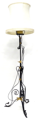 A black painted and gilt wrought iron standard lamp, with oil lamp fitting to the top and a shade, converted to electricity, 180cm high overall.