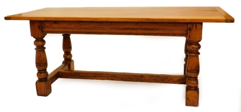 An oak refectory table in late 17thC style, the rectangular planked top with cleated ends, above a moulded frieze on turned supports with H stretcher, 78cm high, the top 84cm x 198cm.