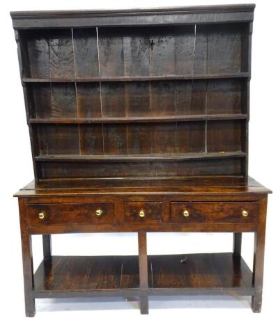 An 18thC oak dresser, the raised back with three plate shelves, the base with one short and two long frieze drawers with later brass turned handles, on plain supports with pot board, 197cm high, 152cm wide, 50cm deep.