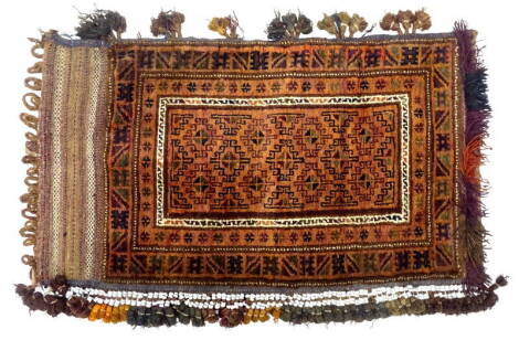 A Turkoman camel bag or Juval, decorated with geometric motives in shades of brown, with tags, tassels and beads to the borders, 115cm x 81cm approx.