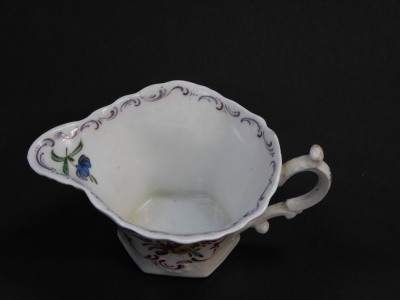 A First Period Worcester polychrome porcelain cream boat, of moulded hexagonal form with C-scroll handle, hand painted with sprigs of flowers in puce reserves, the spout highlighted in yellow and modelled as a shell, unmarked, c.1756/58, 10.5cm wide. - 2