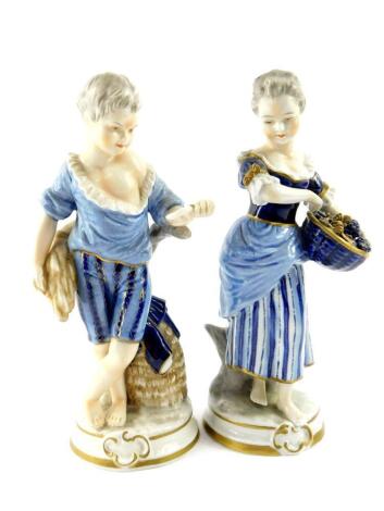 A pair of Unterweissbach 20thC porcelain figures, of a boy and girl, modelled standing with a sheath of corn and basket of grapes respectively, raised on circular bases, printed mark, 21cm high.