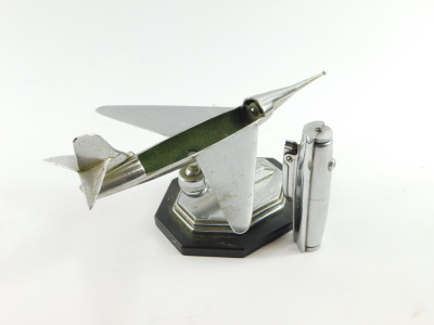 A 1950's Gala Sonic chrome aircraft desk top table lighter, raised on an octagonal plastic base, bears label 'Regd, Designs 869697 869675 880107/56 Pro. Patent 7599/56 As Applicable'., 23cm wide. - 4