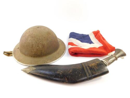 A World War I Brodie helmet, with leather lining and white metal trim, a kukri with damascene decoration, in a leather scabbard, and a Union Jack flag. (3)