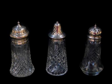 Three Edward VII and George V cut glass and silver lidded sugar casters, comprising Birmingham 1921, Chester 1911 and Sheffield 1924.