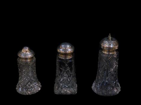 Three Edward VII and George V cut glass sugar casters, with silver lids, Birmingham 1903, 1911 and 1912.