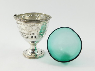 A George III silver sugar basket, with green glass liner, swing handle, pierced and engraved with classical urns, swags and foliate scrolls, oval shield reserve, crest engraved, William Bateman I, London 1820, 5.19oz. - 3