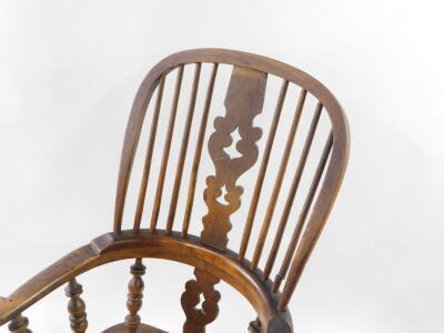 A Victorian oak and elm Windsor chair, with a carved splat and spindle back, solid saddle seat, raised on turned legs united by a double H framed stretcher. - 2