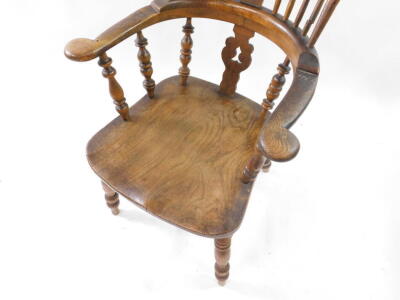 A Victorian oak and elm Windsor chair, with a carved splat and spindle back, solid saddle seat, raised on turned legs united by a double H framed stretcher. - 3