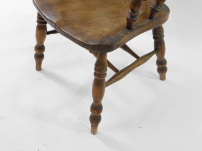 A Victorian oak and elm Windsor chair, with a carved splat and spindle back, solid saddle seat, raised on turned legs united by a double H framed stretcher. - 4