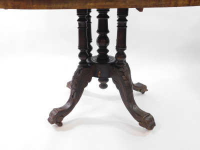 A Victorian walnut and inlaid tilt top loo table, the oval quarter veneered top inlaid with vases of scrolling leaves and line inlay, raised on five turned columns over four leaf carved cabriole legs, on castors, 90cm high, 111cm wide, 86.5cm deep. - 3