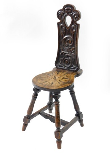 A Victorian oak spinning chair, with a scrolling leaf carved back and seat, raised on baluster turned legs untied by an H framed stretcher.