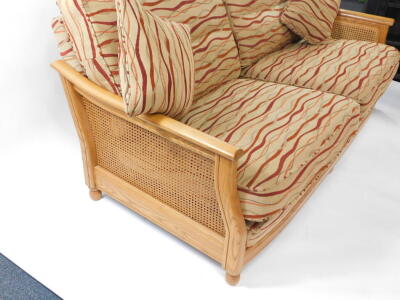 An Ercol elm and bergere two seater sofa, c2007, with wavy striped fabric cushions, 101.5cm wide, 93cm deep, together with a matching armchair. - 4