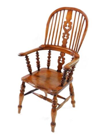 A Victorian oak and elm Windsor chair, with a carved splat and spindle back, solid saddle seat, raised on turned legs united by a double H framed stretcher.