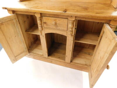 A pine dresser, the two shelf plate rack over a central drawer and recess flanked by cupboard doors raised on a plinth base, 196.5cm high, 133cm wide, 54cm deep. - 4