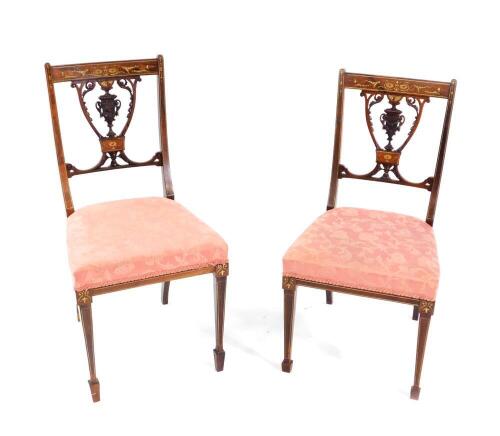 A pair of Victorian rosewood and inlaid salon chairs, with satin wood and ivory inlaid, with carved vase shaped splats, overstuffed seats, raised on tapering square legs, and spade feet.