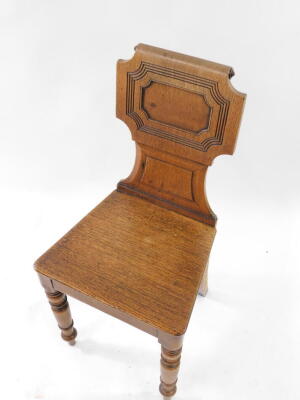 A Victorian oak hall chair, with a carved and scroll back and solid seat, raised on turned legs. - 2