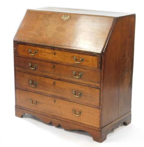 A George III oak bureau, the fall flap opening to reveal a central door, eight recesses and six drawers, over four long graduated drawers raised on bracket feet, 91.5cm high, 99cm wide, 54cm deep.