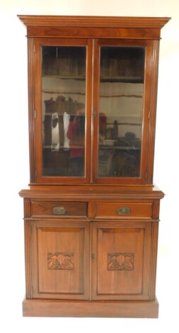 A Victorian mahogany cupboard bookcase, the outswept pediment over a pair of glazed doors opening to reveal three shelves, over two drawers above carved panelled doors, raised on a plinth base, 222cm high, 107cm wide, 43.5cm deep.