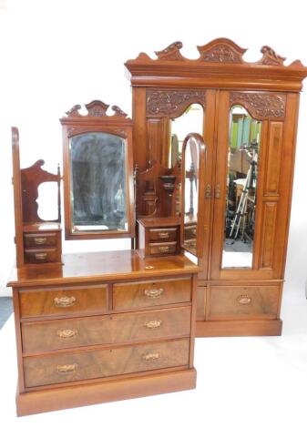 A Victorian walnut double wardrobe and dressing chest, by Blair and Kemp, Horncastle, the wardrobe with outswept pediment over a pair of carved and mirror set doors, the doors opening to reveal hanging hooks over a pair of deep drawers raised on a plinth 