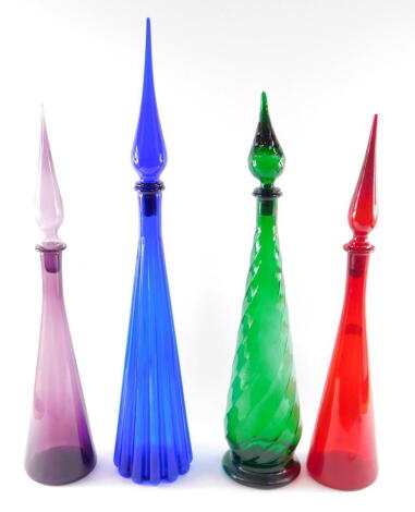 Four Empoli vintage colour glass bottles and stoppers, comprising a fluted cobalt blue bottle 76cm high, spiral fluted emerald green bottle 66cm high, plain amethyst bottle 64cm high, ruby glass bottle 63cm high.