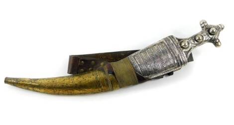 An Indo Persian 19thC Jambaya dagger, the horn grip with silver engraved and embossed mounts, engraved double edged steel blade, and leather scabbard with engraved silver and brass mounts, and brass wire work, with a leather belt, blade 37cm wide, dagger 