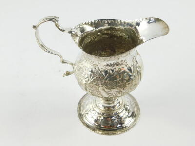 A George III silver cream jug, of ogee baluster form, embossed and engraved with homesteads, rococo shield reserve , monogram engraved, maker TS, London 1819, 2.89oz. - 4