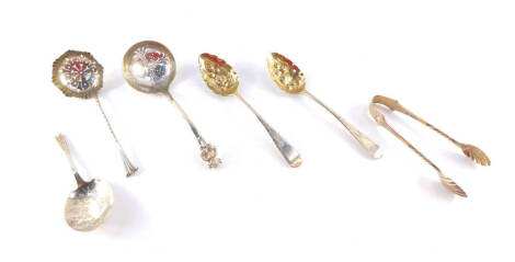 A pair of George III silver berry spoons, London 1809, a pair of Edward VII silver sugar tongs, Sheffield 1903, caddy spoon with engraved floral decoration, Sheffield 1902, Victorian sugar sifting spoon, Birmingham 1883 and a George V silver sugar sifter 