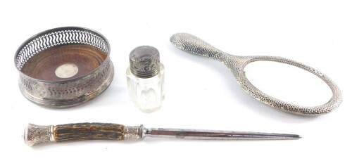 A silver wine coaster with a pierced gallery, Birmingham 1998, an Edward VII cut glass smelling salts bottle with a silver screw lid, Birmingham 1908, an Edward VII silver backed hand mirror with a hammered finish, Chester 1905, and a Georgian steel with