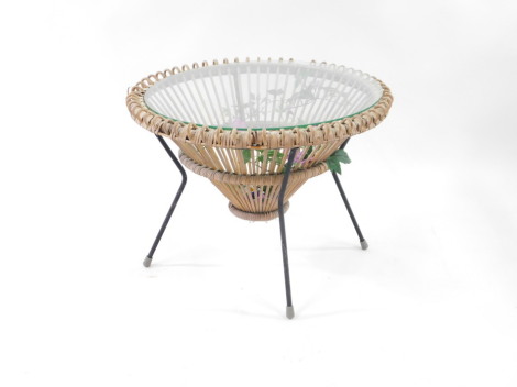 A Franco Albini style mid century wicker circular coffee table, with glass top, contained within a cast iron circular frame and four rod legs, rubber capped, 51cm high, 67cm wide.