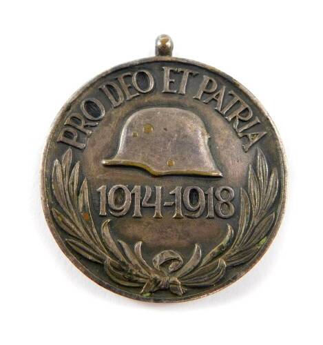 An Austro Hungarian WWI war medal, obverse a helmet and 1914-1918 'Pro Deo a et Patri', reverse the Arms of the Hapsburgs.