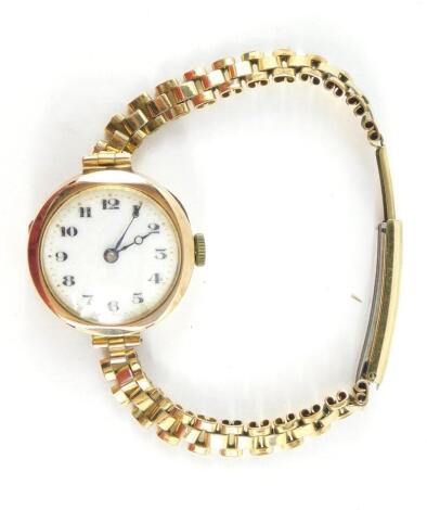 A Buren lady's 9ct gold circular cased wristwatch, white enamel dial bearing Arabic numerals, fifteen jewel movement, on a plated strap.