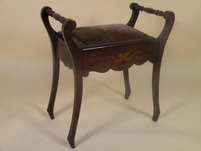 An Edwardian mahogany piano stool with a plush upholstered seat