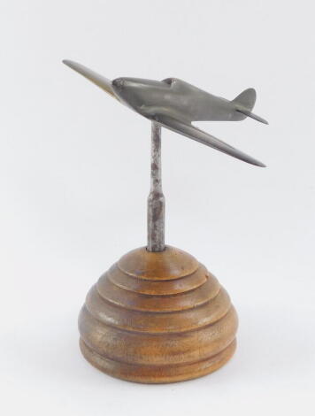 A brass desk stand modelled as a spitfire, raised on a bee hive shaped circular stand, 18cm high.