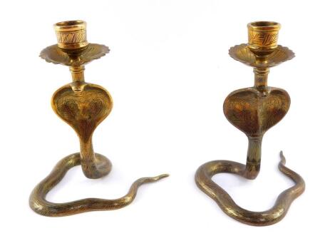 A pair of Indian early 20thC brass candlesticks, cast of cobras, 13.5cm high.