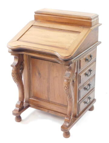 A Victorian style hardwood Davenport desk, the lidded rectangular top over a hinged flap, opening to reveal a fitted interior of eight drawers with four drawers to the left side and four to the right, raised on a shaped base on feet, 82cm high, 54cm wide,