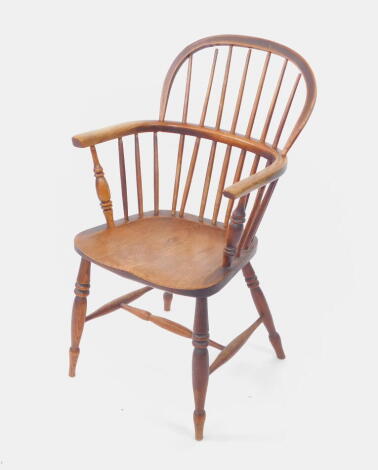 A 19thC oak and elm Windsor carver chair, with spindle back, solid saddle seat, raised on turned legs united by an H frame stretcher.