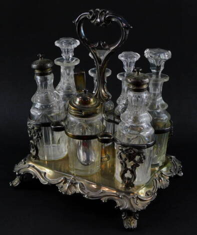 A Victorian silver plated seven bottle cruet, the stand embossed with flowers and foliate scrolls, with cut glass bottles, four having stoppers, two with plated sifting lids, the seventh with a hinged lid and spoon, 26cm high.