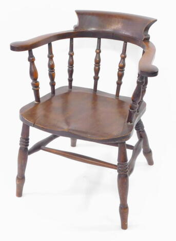 A Victorian oak and elm smoker's bow chair, with solid saddle seat, raised on turned legs united by a double H frame stretcher.