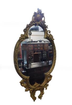 A 19thC gilt wood and gesso wall mirror, of quatrolobe form with shield floral and foliate moulding, 130cm high, 64cm wide.