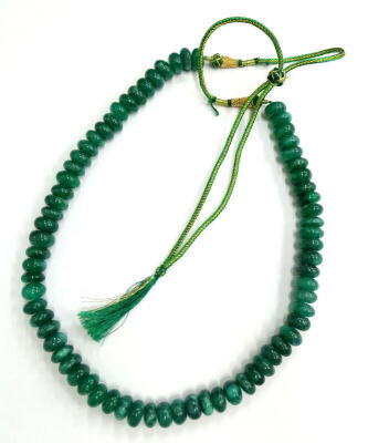 An emerald beaded necklace, with various round shaped earth mined rich green stones, totalling approx 1118.50cts overall, on green string, with gold coloured fasteners, 80cm long overall.