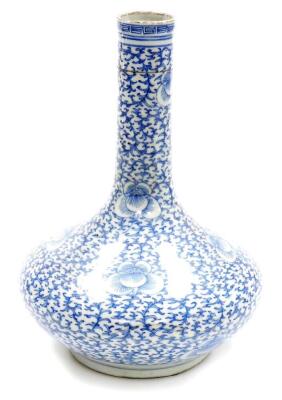 A Chinese porcelain blue and white bottle vase, with slender neck decorated with an all over design of scrolling peonies, unmarked, partial collectors label to base, probably 19th century. 31cm high.