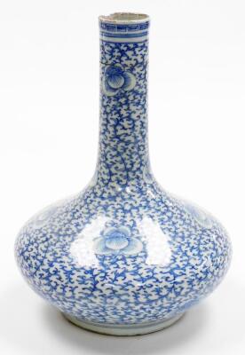 A Chinese porcelain blue and white bottle vase, with slender neck decorated with an all over design of scrolling peonies, unmarked, partial collectors label to base, probably 19th century. 31cm high. - 2