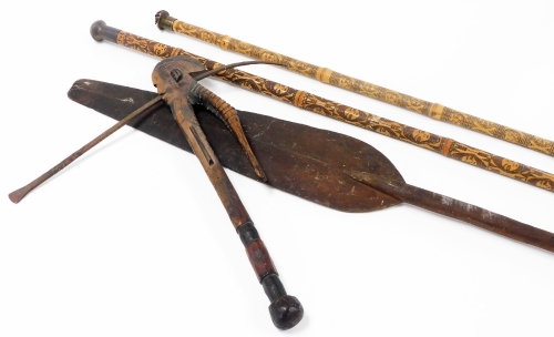 A collection of African tribal weaponry, cross bow with turned handle and figure head with metal section, the main body 52cm wide, a bamboo finish staff decorated with figure head and geometric pattern, various other spears, etc. (a quantity)