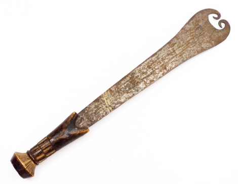 An African tribal cleaver, with curved blade tip and heavily carved handle, with compressed circular pommel, 55cm wide.