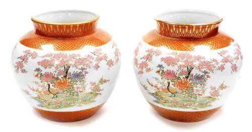 A pair of Japanese Kutani porcelain jardinieres, decorated with pheasants chrysanthemums and cherry blossom between lappet and diaper borders in gilt, seal marks to the base. 20thC, 23cm high. (2)